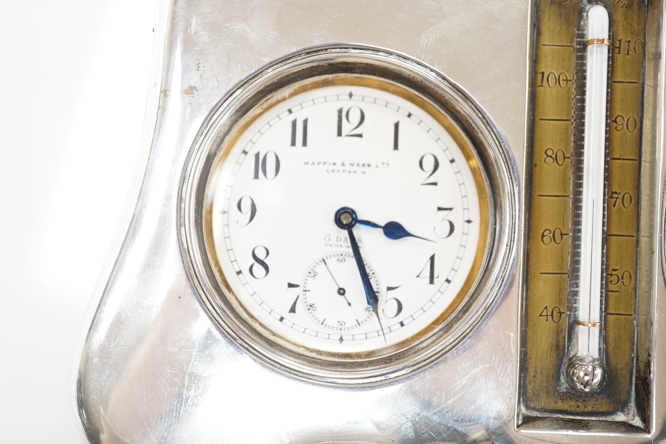 An Edwardian silver mounted leather clock/barometer desk stand, containing a pocket watch, retailed by Mappin & Webb, a similar barometer and a central thermometer, Henry Matthews, Birmingham, 1905, width 21.2cm.